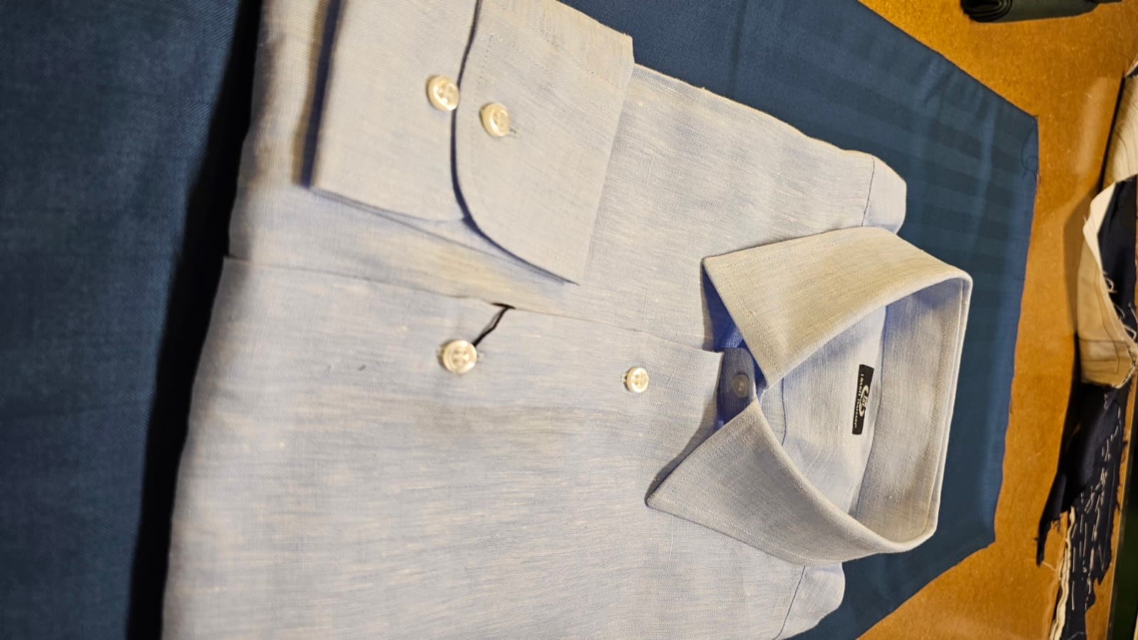 Pale blue linen shirt on teal cloth, cuff detail